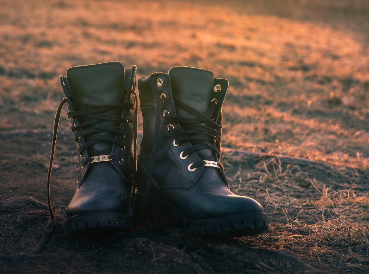 Close-up of untied leather work boots on ground in Boden, Sweden at sunset.